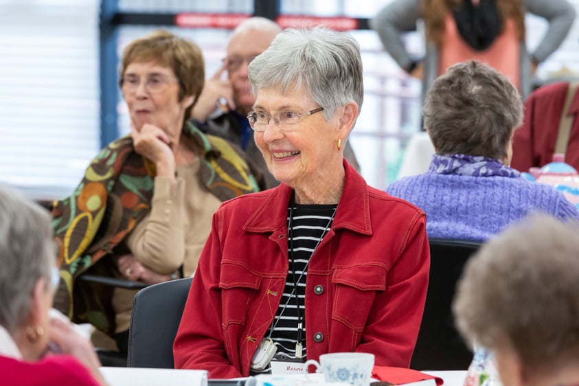 Close-up of a smiling senior woman sitting at a table