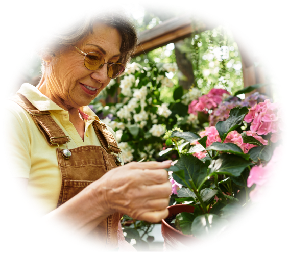 A woman tends to blooming flowers in a garden.