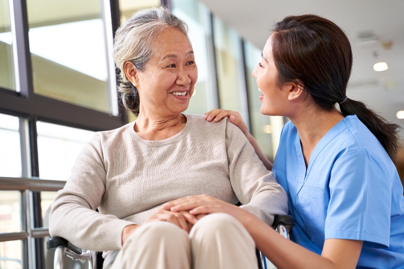 Nurse talking to a resident who is in a wheelchair.