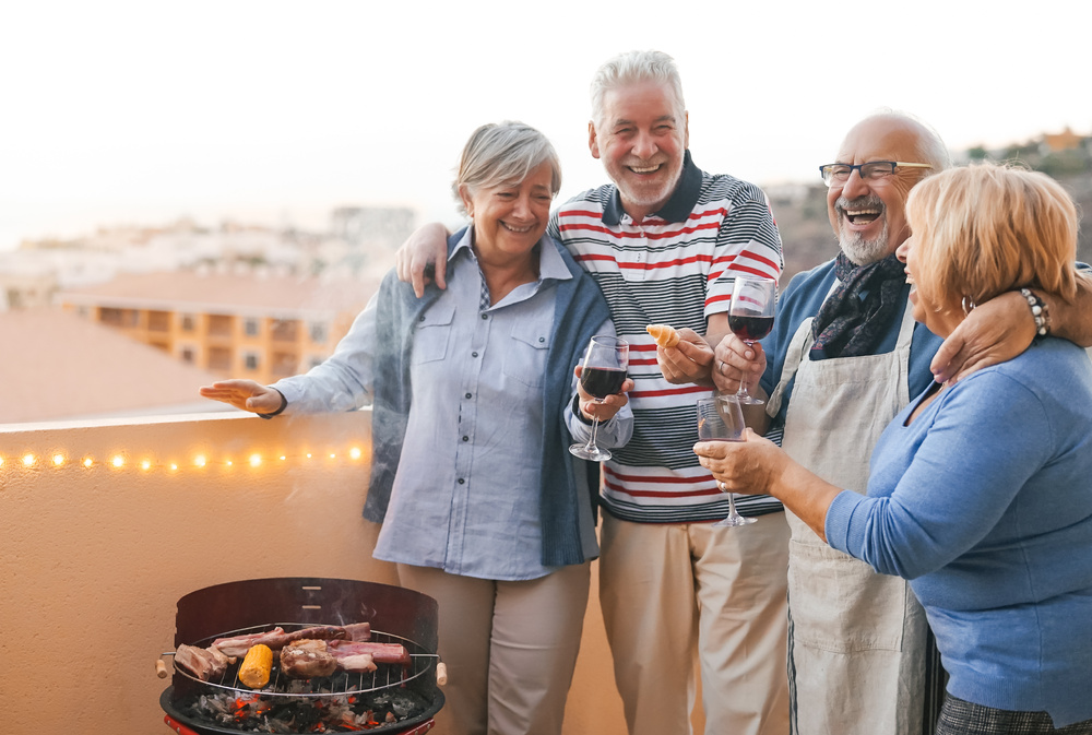 group of senior friends enjoying wine outside on a rooftop