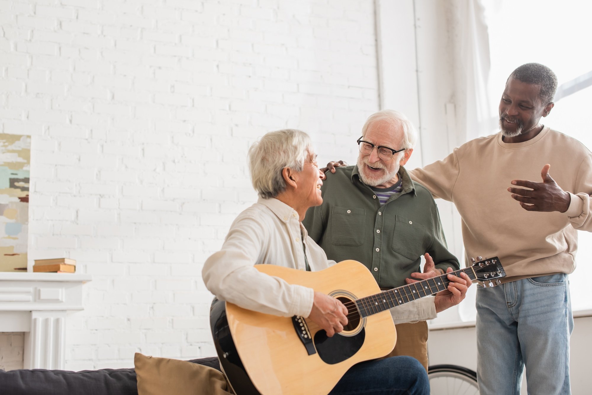 group of three friends playing guitar