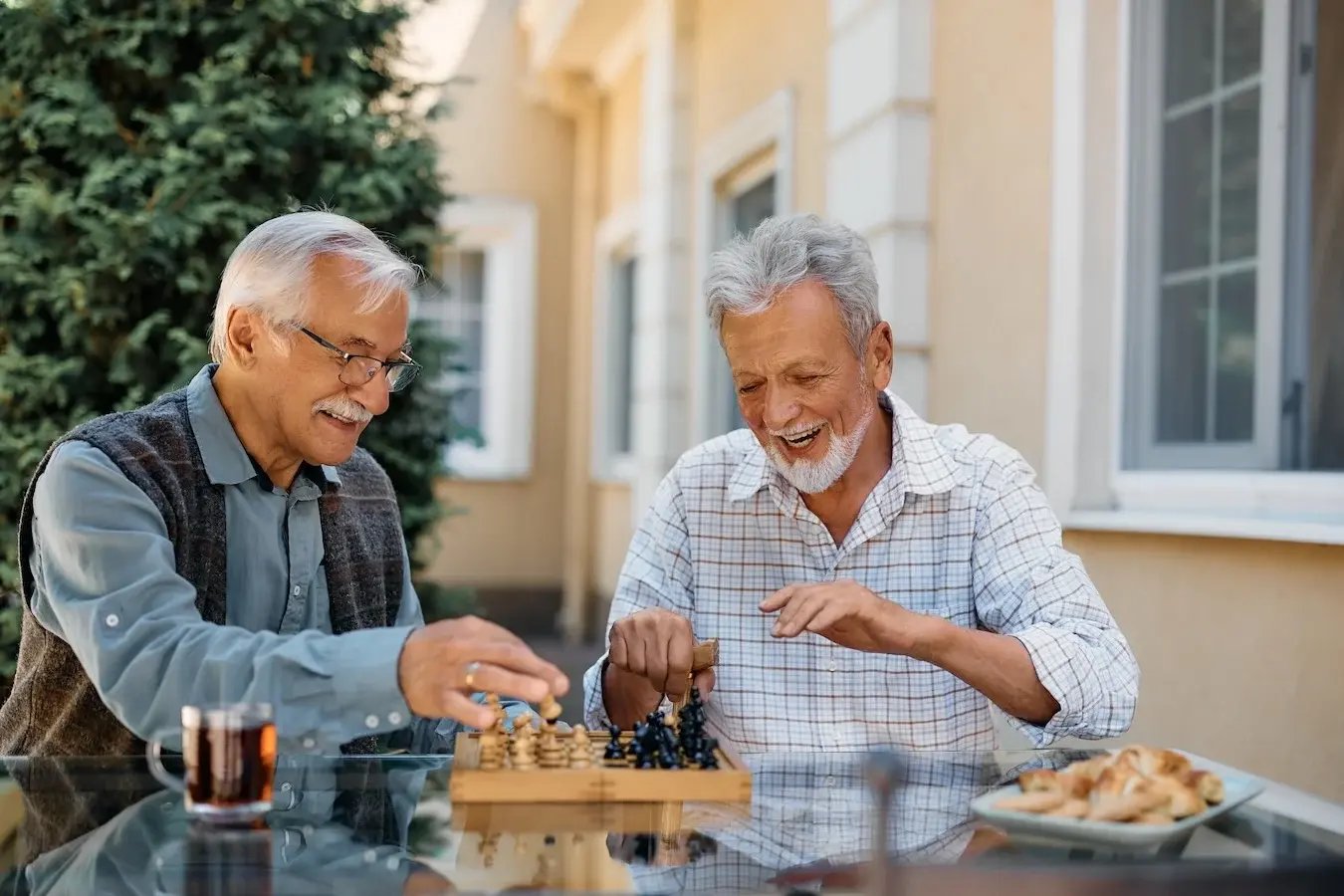 two men playing chess together outside