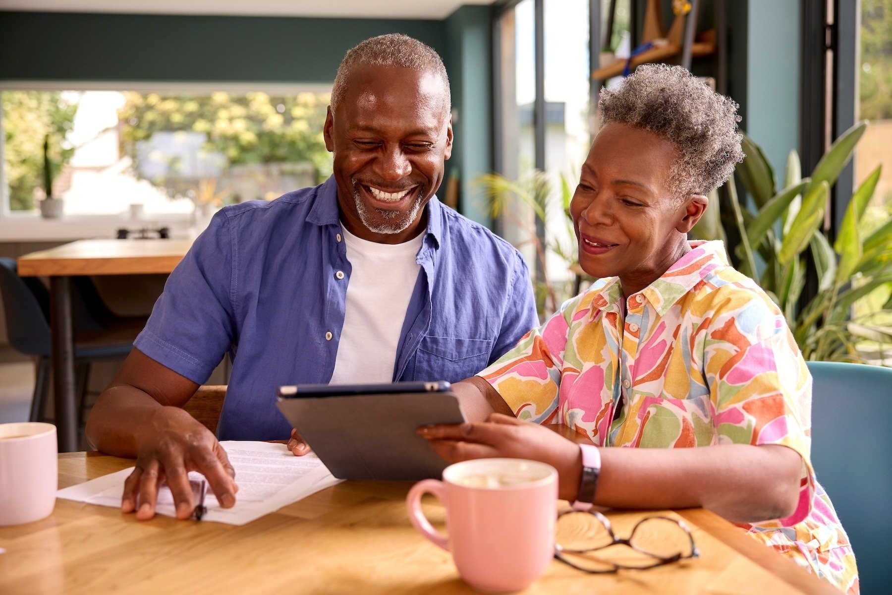 man and woman sitting at table with tablet going through finances
