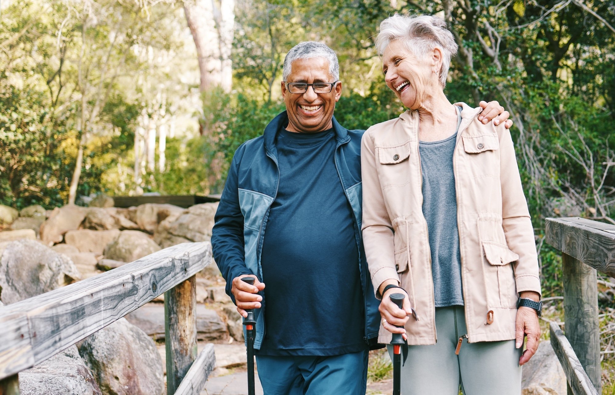 man and woman walking outside across a wooden bridge