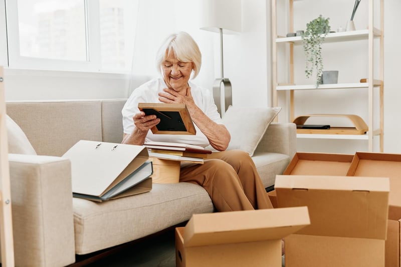 older woman sitting on couch looking at old photos