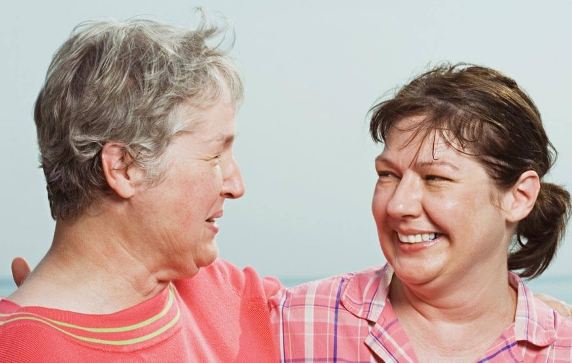 Senior woman hugging and smiling with her adult daughter