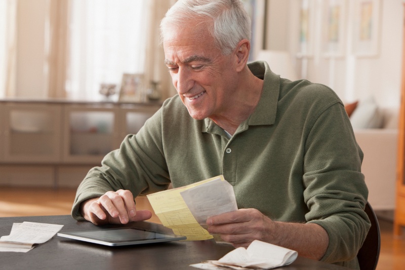 Retired man reviewing his receipts and expenses. 
