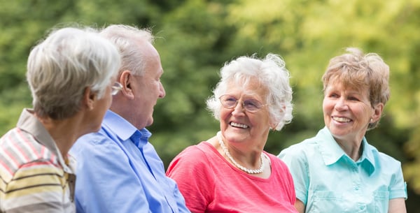 Four seniors having a conversation outside