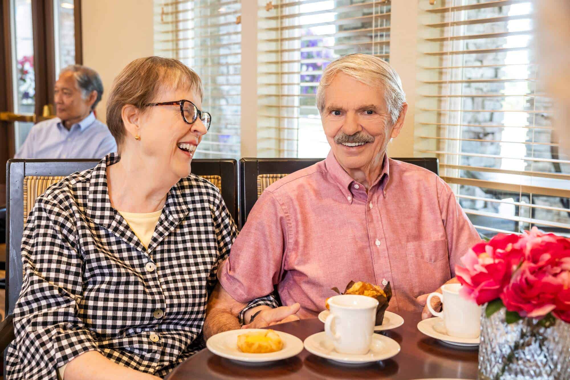Couple seated eating muffins	