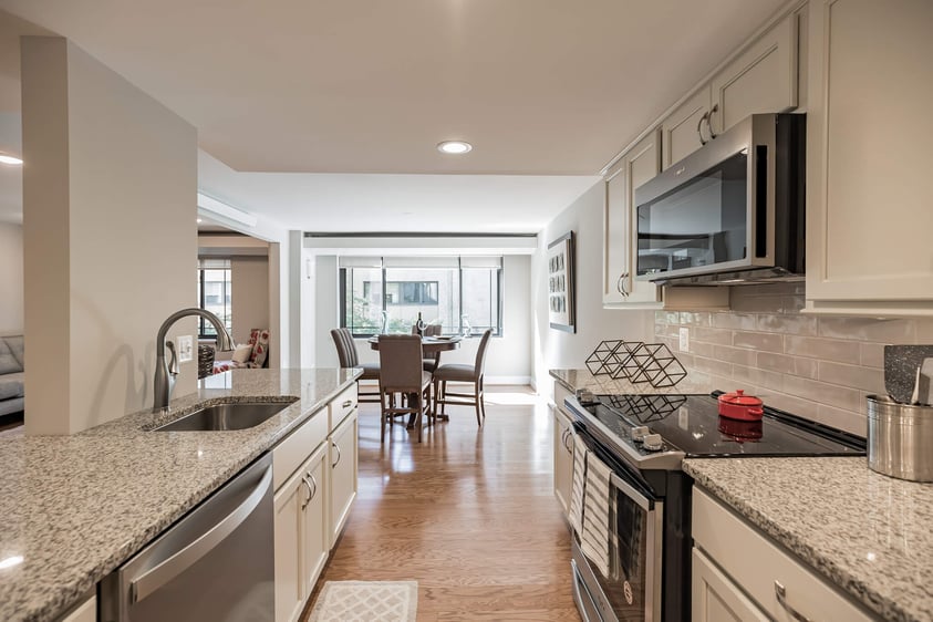 White kitchen with stainless steel appliances in an apartment at Rydal Park & Waters