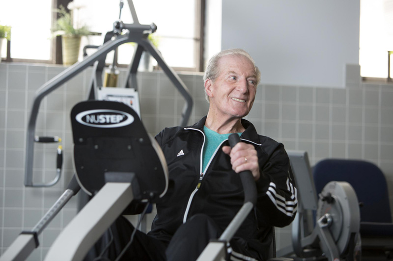 Senior man exercising using a NuStep machine in the Spring Mill Pointe fitness center