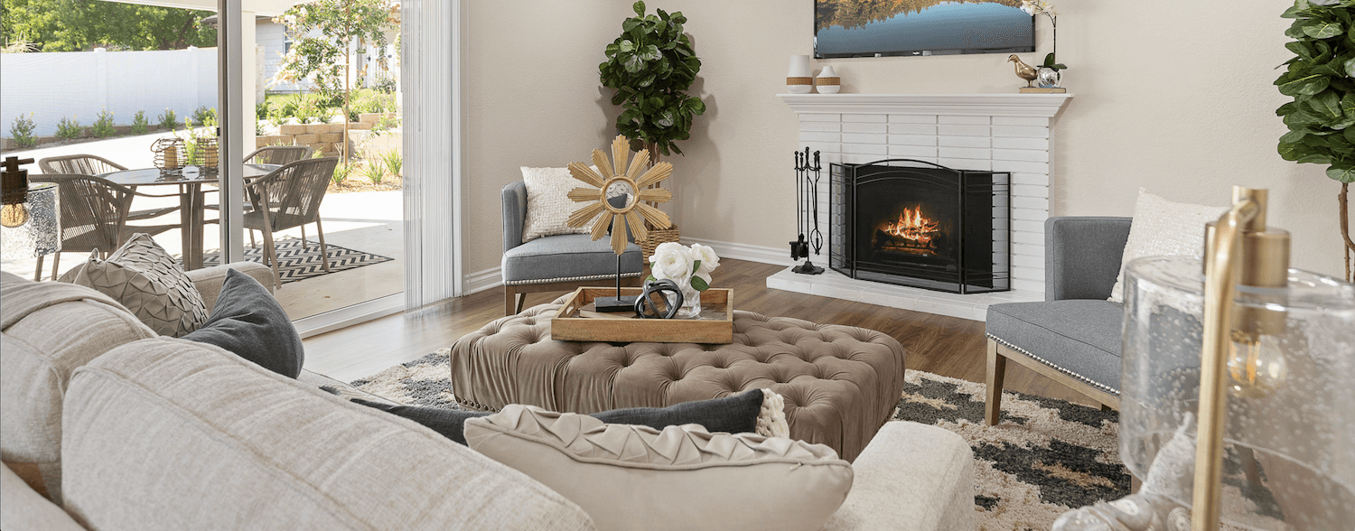 Living room with a fireplace and sliding glass doors leading to a patio of a home at Plymouth Village