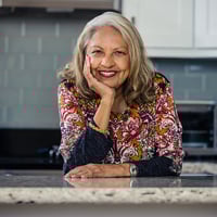 Hezla, HumanGood resident, smiling in kitchen