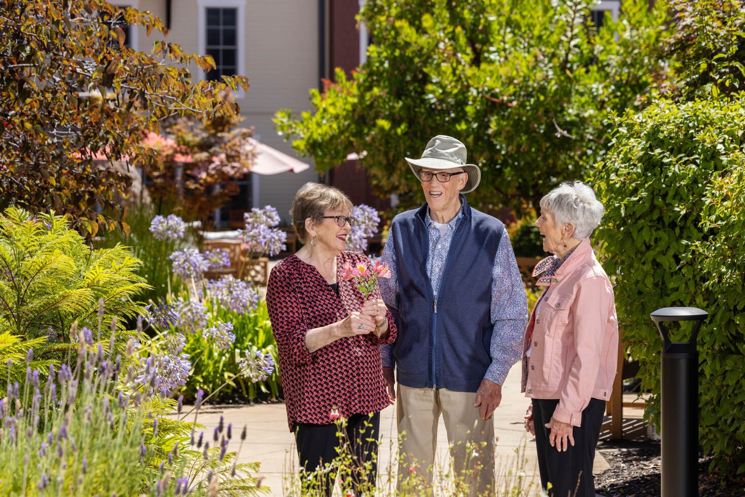Two senior women and a senior man walking through the grounds of The Terraces at Los Altos