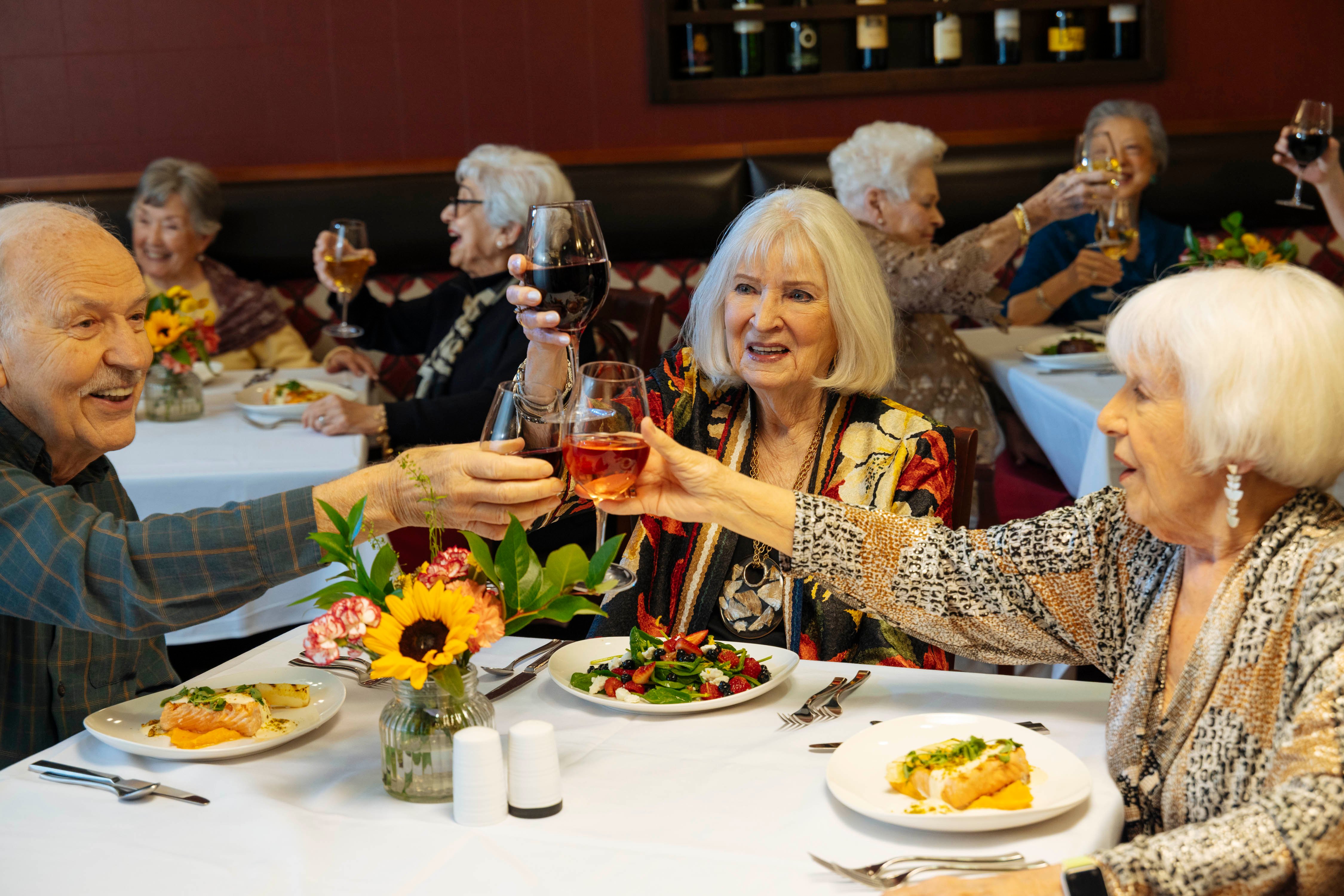 Friends sitting at restaurant table having a toast.