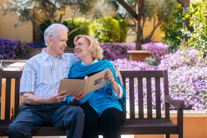Couple reading a book on a bench