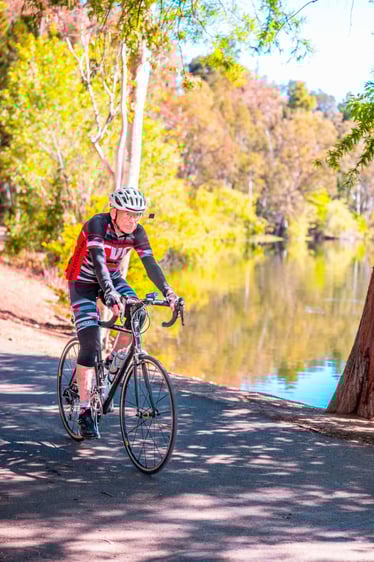 Senior man riding his bike by the water