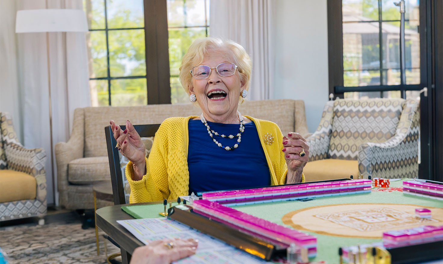 Smiling senior woman playing mahjong