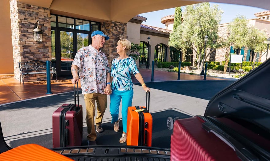 seniors loading up a car with luggage to travel