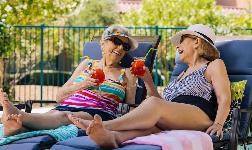 Senior friends, enjoying cocktails next to the pool