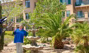 senior woman standing in front of outdoor water fountain