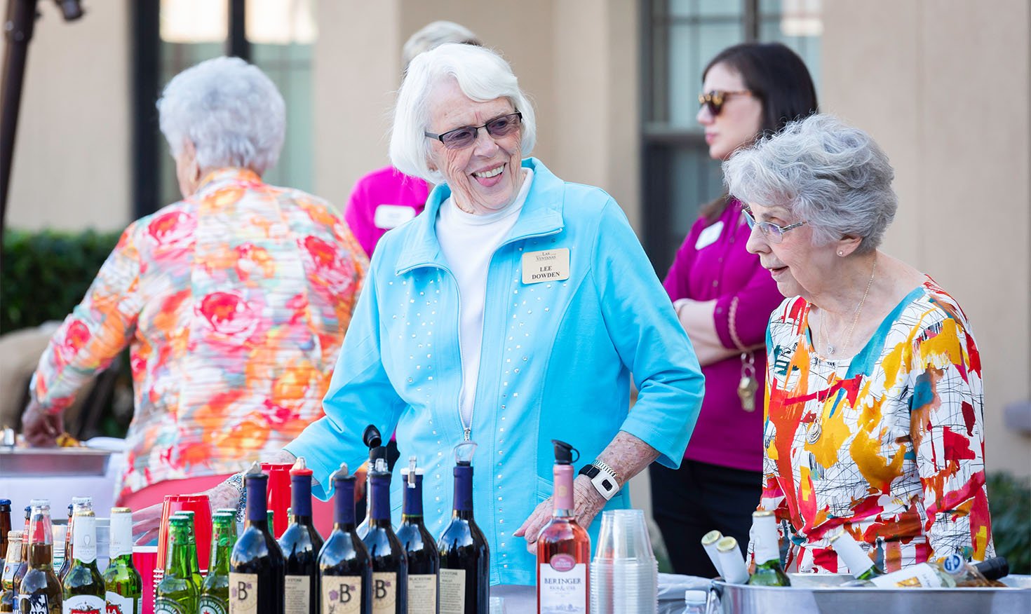 Senior women at a drinks table during a community event