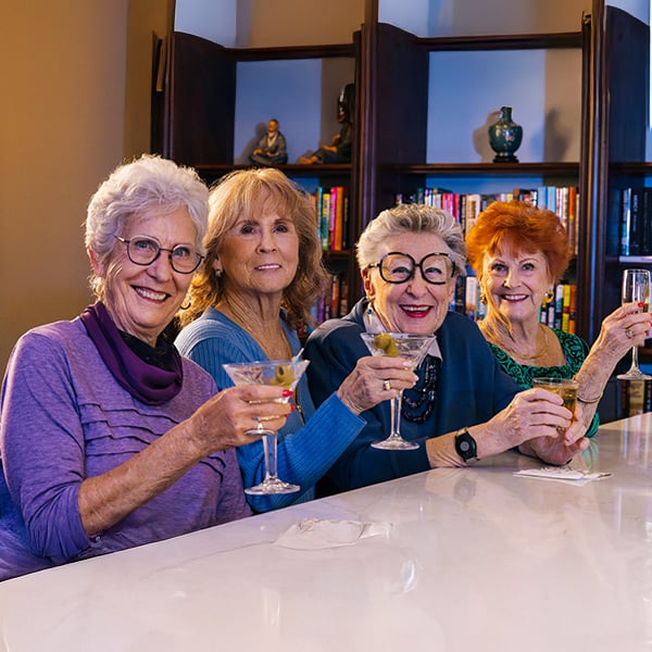 Four senior women drinking martinis at the bar