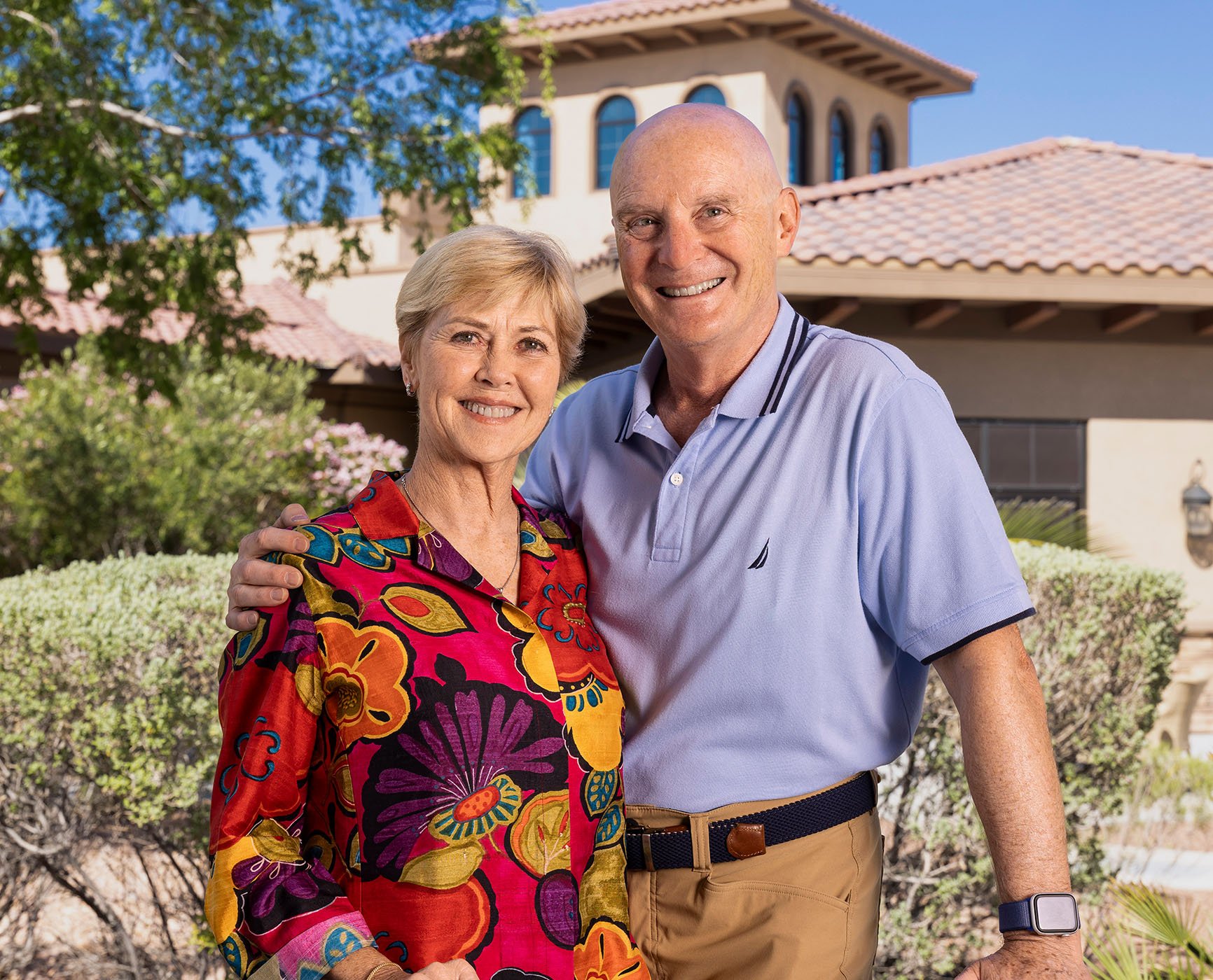 Smiling senior couple with their arms around each other outside Las Ventanas