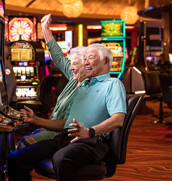 Senior man and senior woman sitting at slot machines in Red Rock Casino