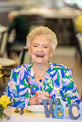 Nancy smiling while sitting at a table
