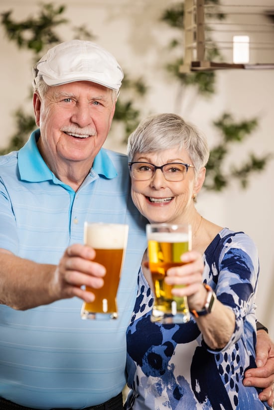 June and David smiling and cheering a glass of beer.