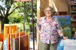 Lady standing next to all of her art