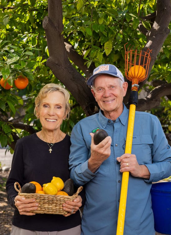 Jennifer and Bill are holding a basket of fresh-picked fruits
