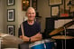 Joe sitting behind his drumset, holding drumsticks