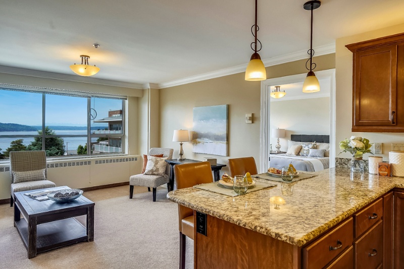Living room with large windows and an adjacent kitchen