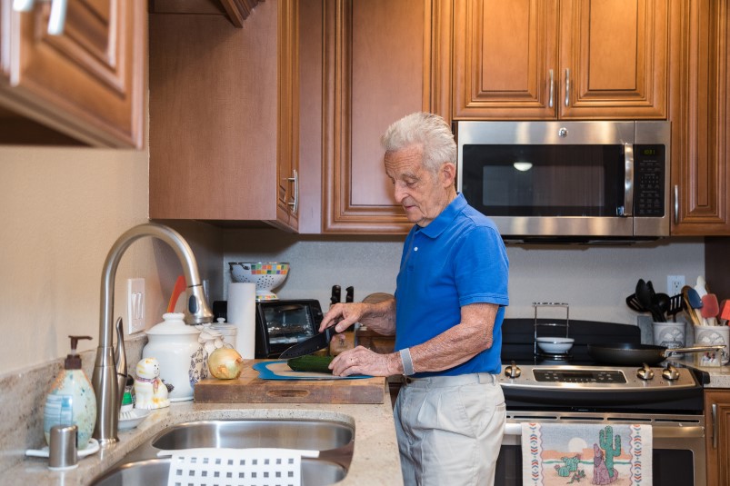 Man cutting a zucchini in his kitchen