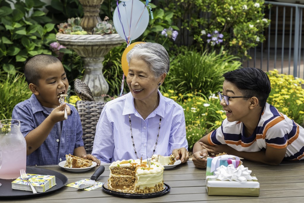 Woman enjoying birthday cake with her grandsons