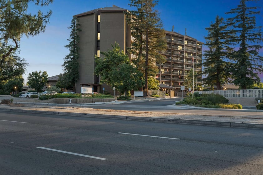 Exterior of an apartment building at Rosewood, a Life Plan Community in Bakersfield, California, at night