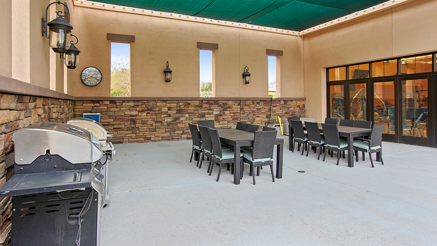 Covered patio with tables, chairs and barbecue grill at Las Ventanas