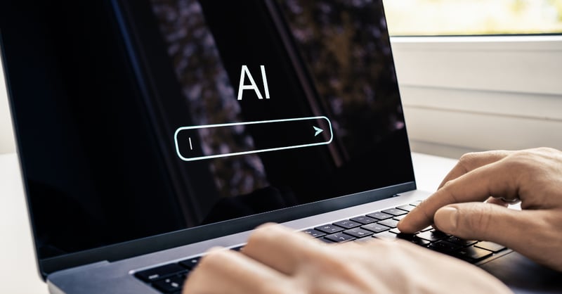 person typing on laptop using an AI website