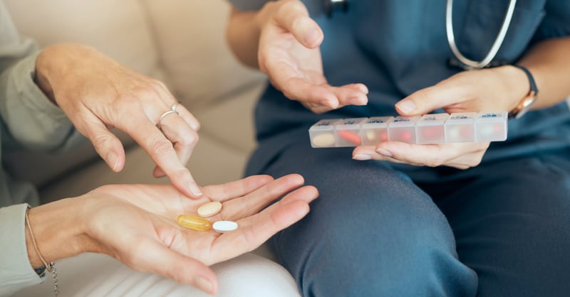 Close-up of two people, one in medical attire, discussing medication.