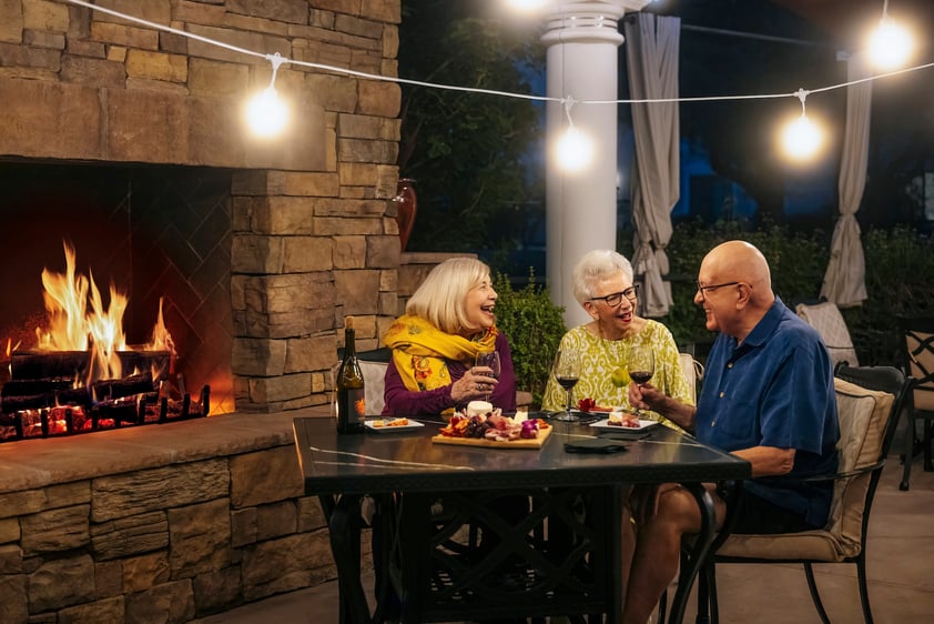 3 people eating by bistro fireplace