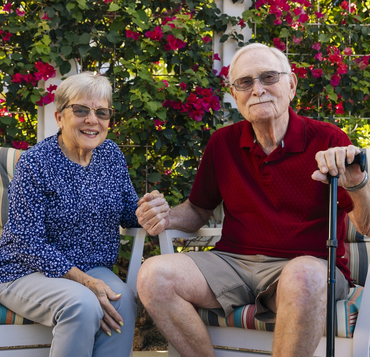 Couple sitting on bench together outside in garden