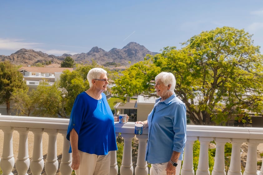 Two ladies on balcony with mountains in the back