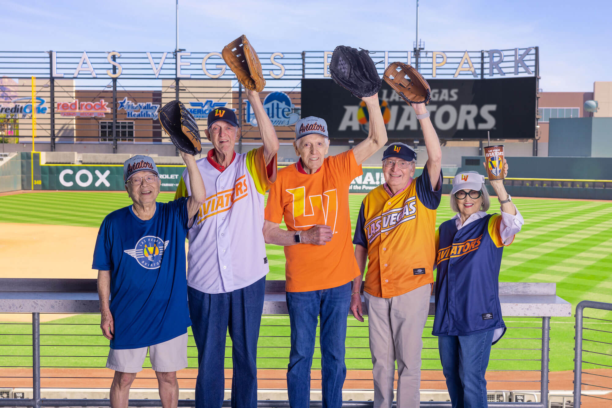 Five seniors holding up baseball gloves at Las Vegas Ballpark