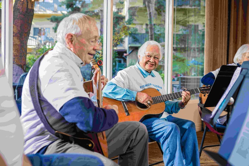 two friends smiling and playing guitar