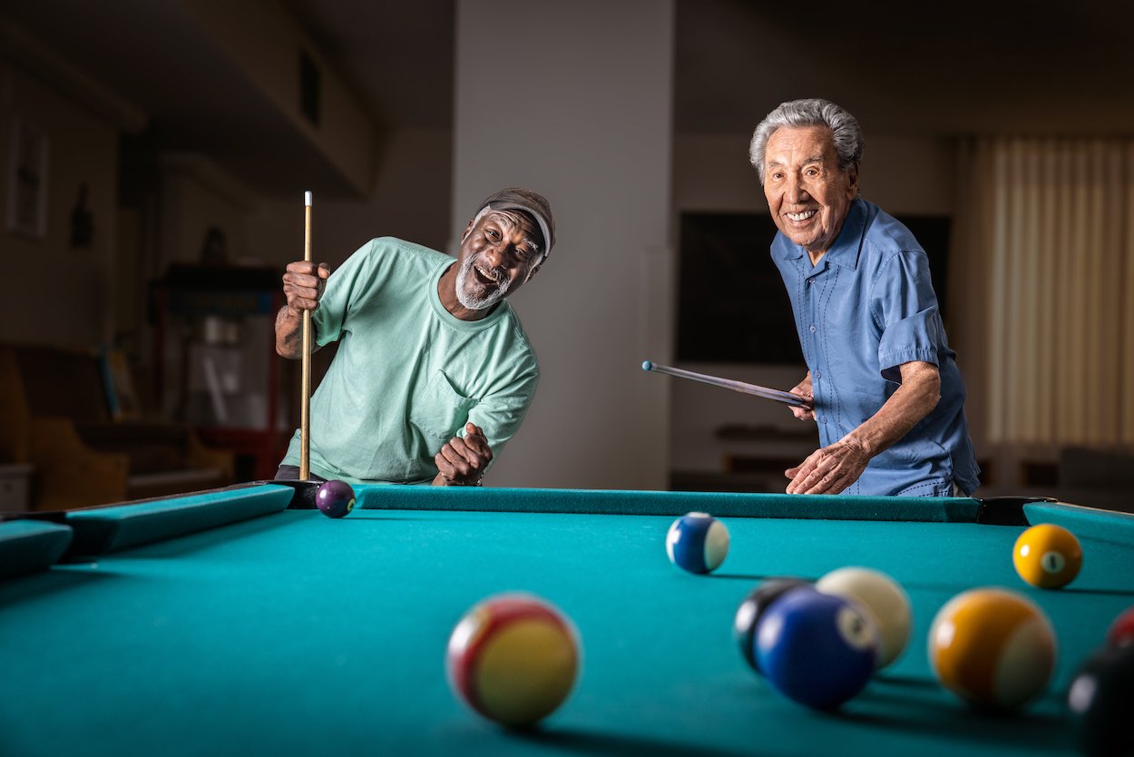 two friends playing billiards 