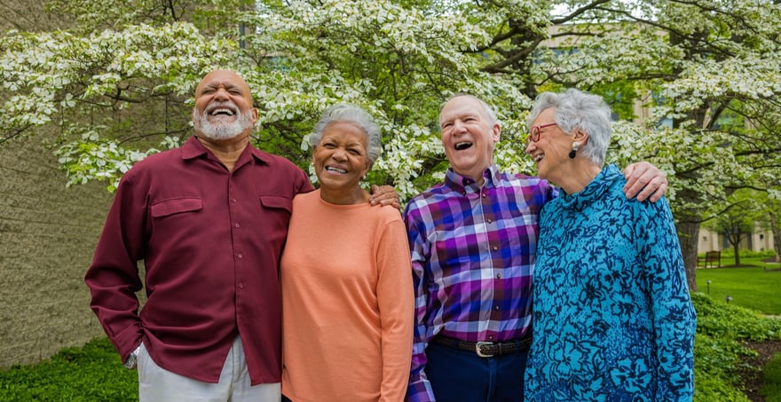 Four seniors standing in front of a tree