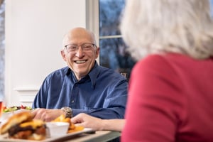 Senior man smiling at dinner.