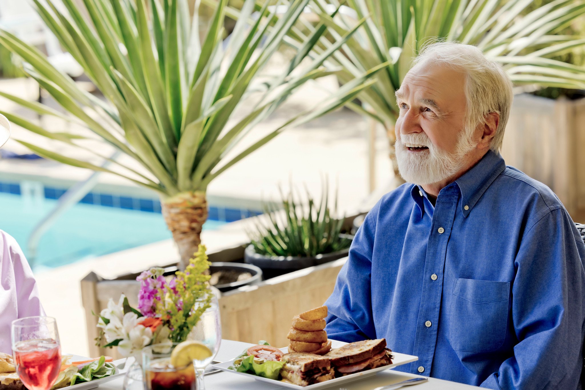 man close up poolside dining